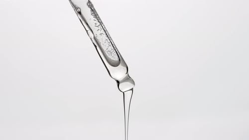 Clear Liquid Dropping From Glass Pipette