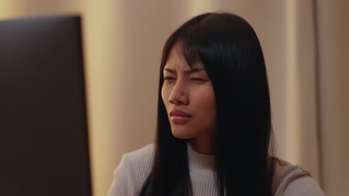 Tired Young Woman Rubbing Eyes at Computer