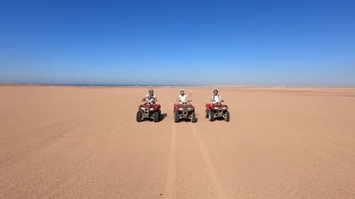 People Riding ATVs in a Hot Desert