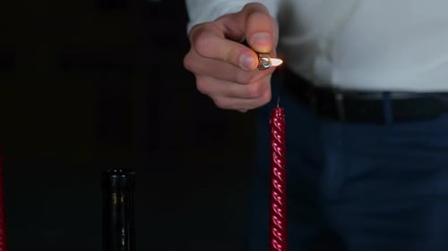 Close Up of Young Man Hand Lighting Candles on Table Outdoors on Romantic Date in Evening Preparing