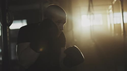 Male Boxer Punching Heavy Bag During Workout