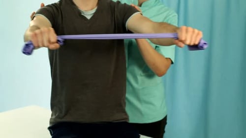 Man Using Resistance Band with Physical Therapist