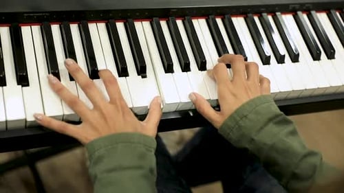 Female hands playing the piano in the studio - close up
