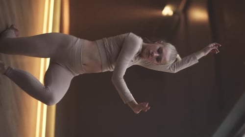 Young Woman Dance in a Sports Room Flexible Woman Performs a Stretching Dance Vertical Video for