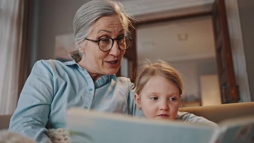 Grandmother Reading with Granddaughter Indoors