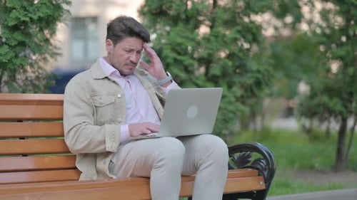 Man on Park Bench Using Laptop Computer