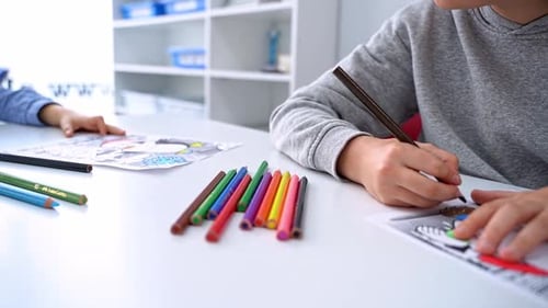 Children Drawing Paint with Colorful Pencils Coloring Book in Educational Class at School