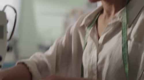 Female Tailor Stitching Fabric on Sewing Machine in Studio