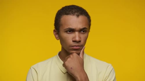 Young Adult Thinking Against Yellow Backdrop