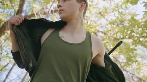 Soldier Puts on Jacket While Listening for Strange Movement in Forest