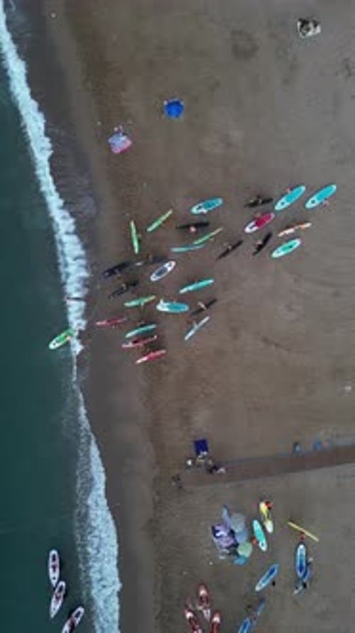 Aerial video on Barcelona's coastline people doing a sap.