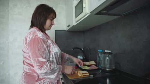 Woman Preparing Sandwich in Kitchen at Home