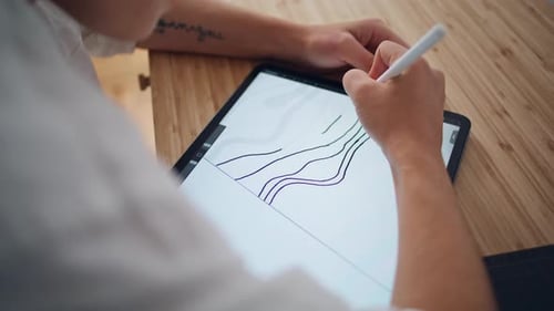 Digital Artist Drawing on Tablet at Wooden Desk