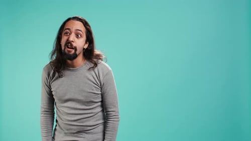 Retrato de un hombre rencoroso haciendo caras tontas exageradas imitando a alguien
