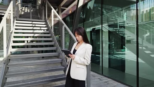 Businesswoman Using Digital Tablet Near Modern Office Building