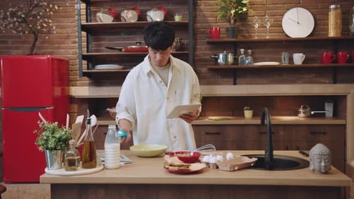 Young Adult Cooking in Modern Home Kitchen