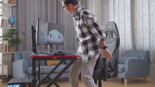 Young Adult Designs Car on Computer in Living Room