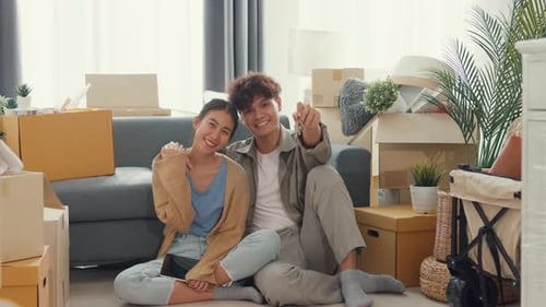 Smiling Couple Shows Keys in New Home