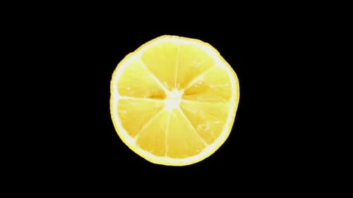 Rotating Slice of Yellow Lemon on Black Background