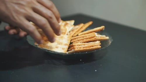 Crispy Crackers Arranged on Glass Plate with Hand