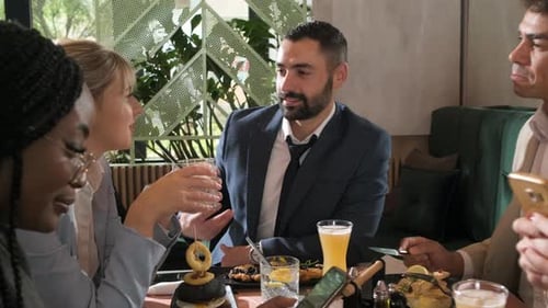 Group of people sitting in a restaurant at a business lunch.