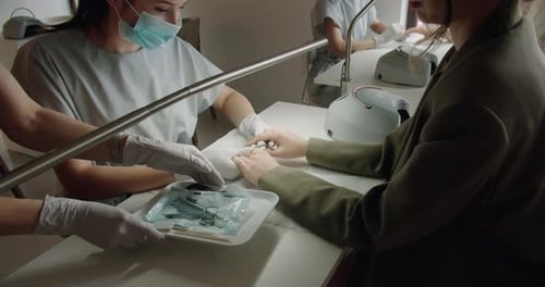 Manicurist Giving Manicure in Bright Nail Salon