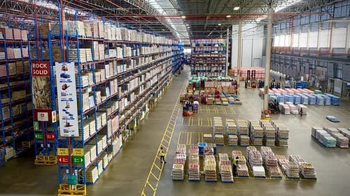 Large food distribution warehouse workers forklifts moving bulk product