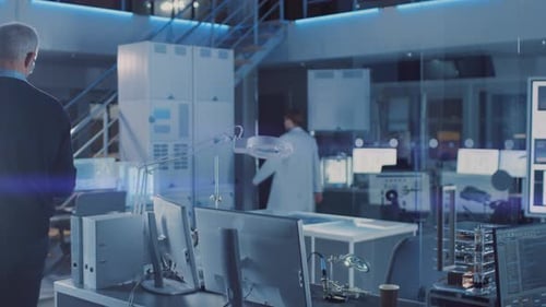 Engineer with Tablet Inspects High-Tech Laboratory Equipment