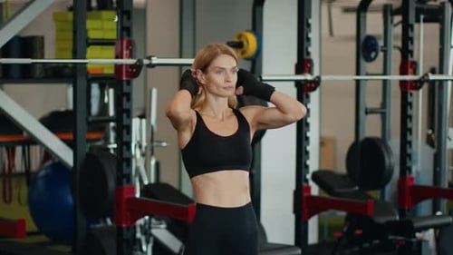 Active Middle Aged Woman Athlete in Sport Suit Fixing Her Hair Enjoying Result of Workout at Gym