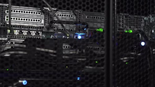Blinking green lights on computer servers in a dark room - Close up