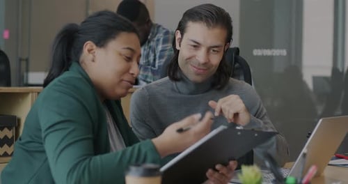Cheerful Man and Woman Colleagues Talking Laughing Reading Document in Open Space Office