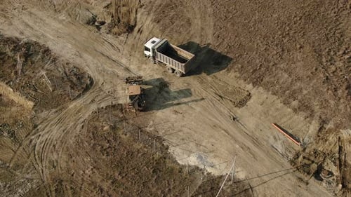 Aerial View of a Tractor That Loads Soil Into the Back of a Truck