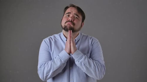 Man Pleading With Hands Together in Supplication