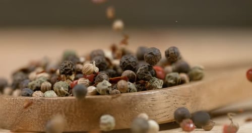 Mixed peppercorns in a super slow motion. Dry mix peppercorns close up.