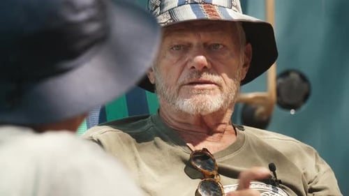 Elderly Man Talks with Another Person During Outdoor Interview