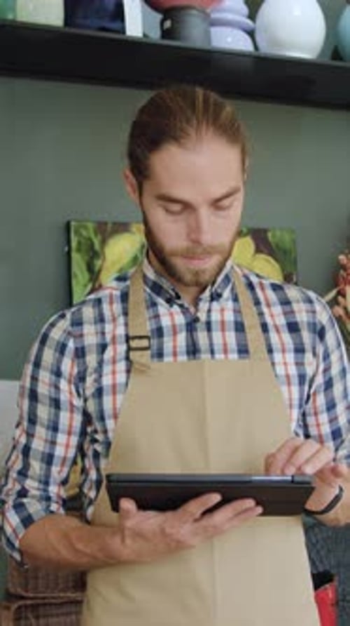 Man Using Tablet Smiles at Camera in Store