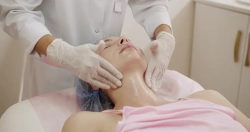 Professional Beautician Giving Facial Treatment in Modern Spa