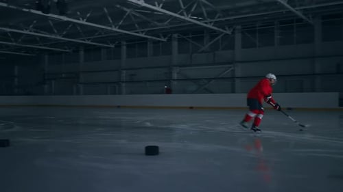 Highintensity Footage of a Hockey Player in a Red Jersey Training on the Ice Moving Quickly and