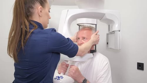 Healthcare Worker Adjusts Dental Scan Equipment on Patient