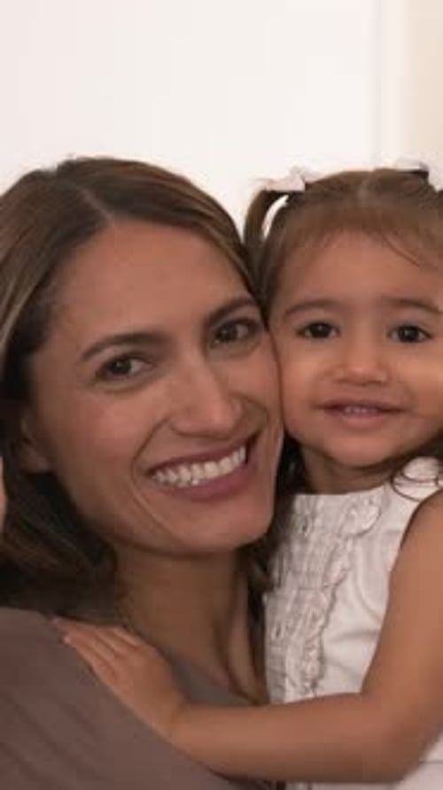 Happy Mother Embracing Her Young Child Indoors