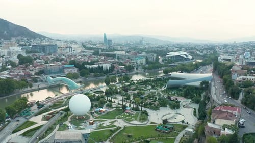 Aerial view over Rike park in Tbilisi, Georgia. Backward movement, pan to right. 4k footage
