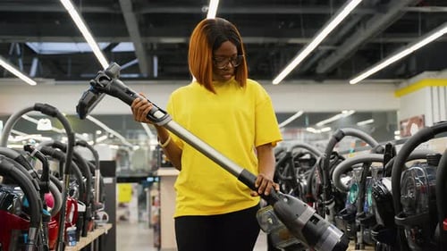 African American Woman Buying Vacuum Cleaner in Tech Store