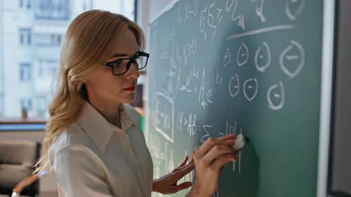 Woman Tutor Teaching Math Writing Formulas at University Blackboard Closeup