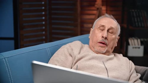 Senior Man Napping on a Blue Couch
