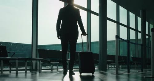 Business Traveler with Luggage at Airport Terminal