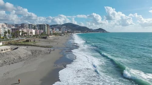 Aerial Video Scenic Beach Transformed By Rolling Storm Waves and Swirling Foam Patterns
