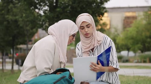 Muslimische Studentinnen studieren zusammen in einem Park
