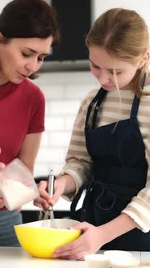 Teen and Adult Cooking Together in Kitchen