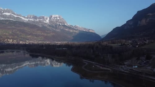 Ascending aerial revealing the town of Sallanches and the mountains reflections on the Passy lake. F