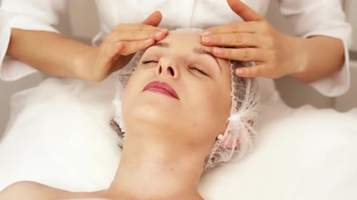 Woman Receiving Relaxing Facial Massage at Spa